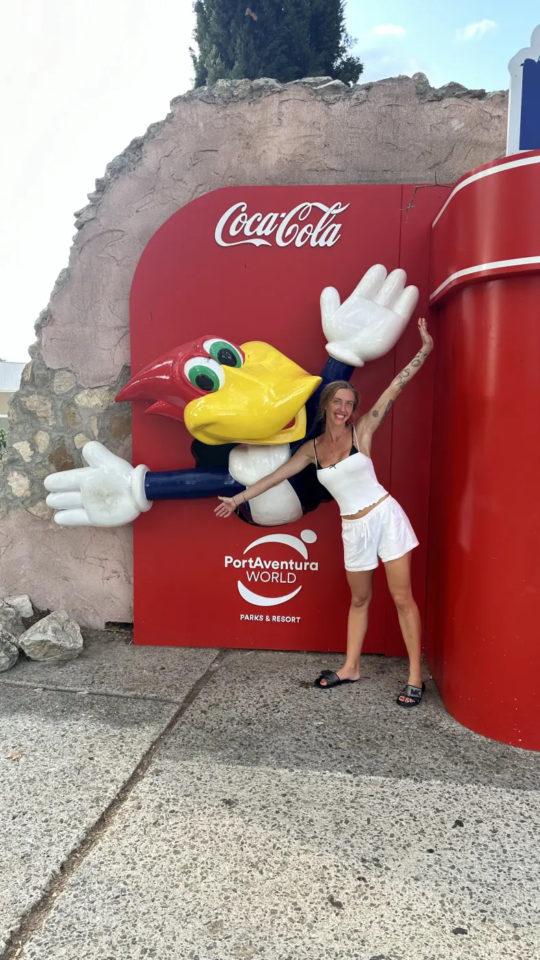 Tú en PortAventura, con los brazos abiertos junto al Pájaro Loco.